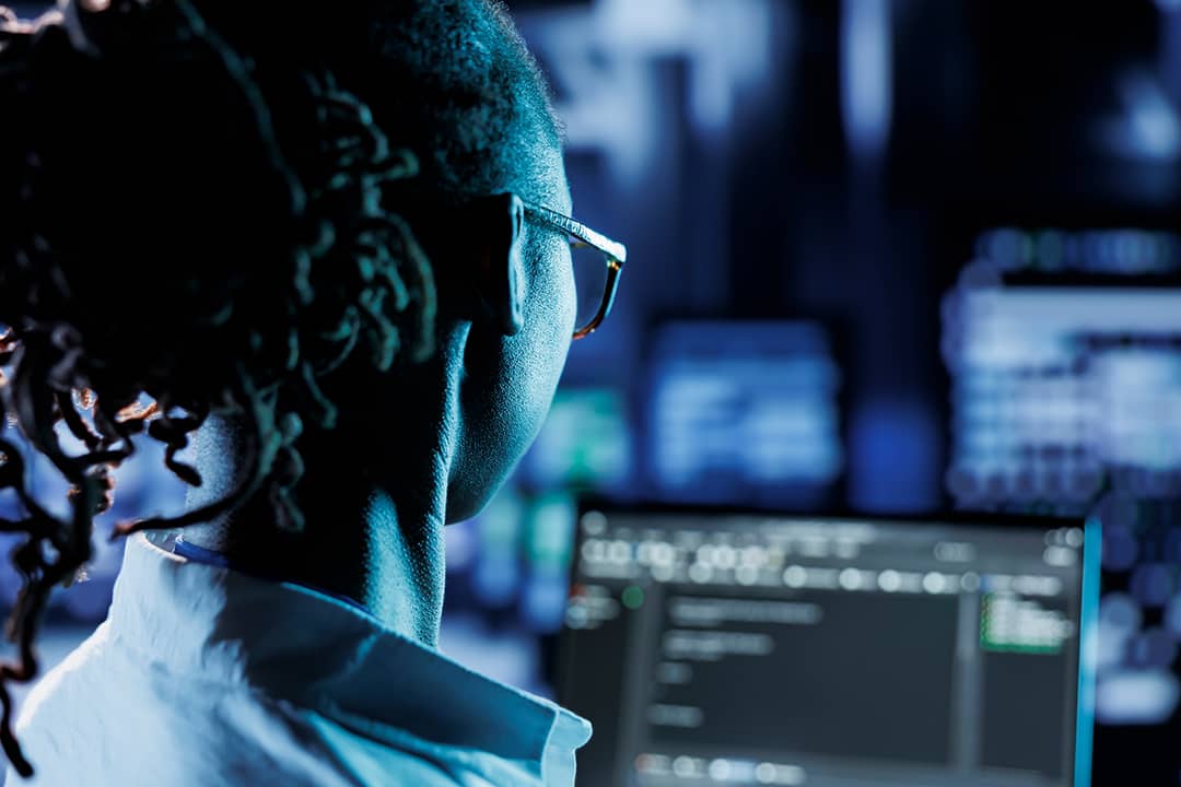 A trained cyber professional running code or program in a computer.